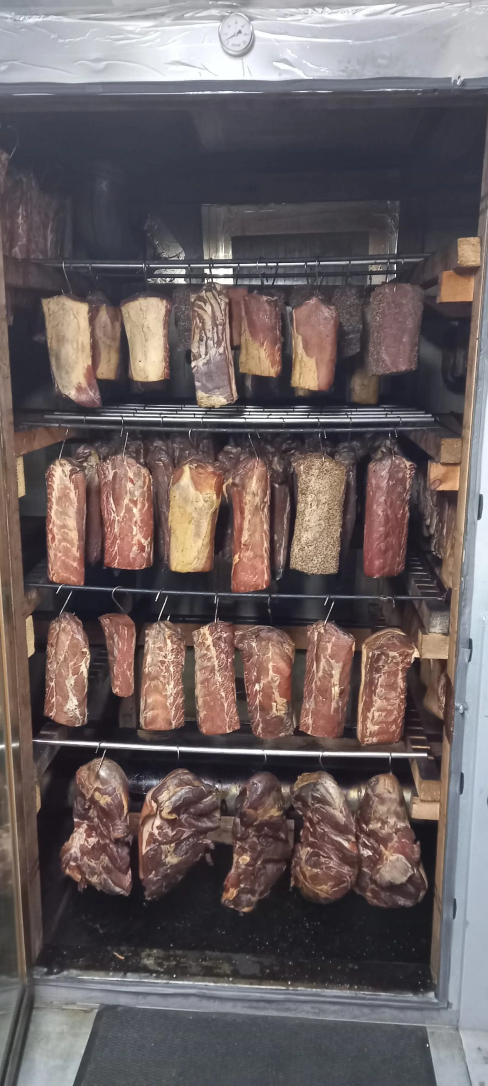 Vollbeladener Räucherofen mit Speck, Karree und Würsten